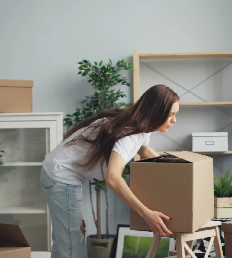 Woman unpacking moving boxes in a bright new home